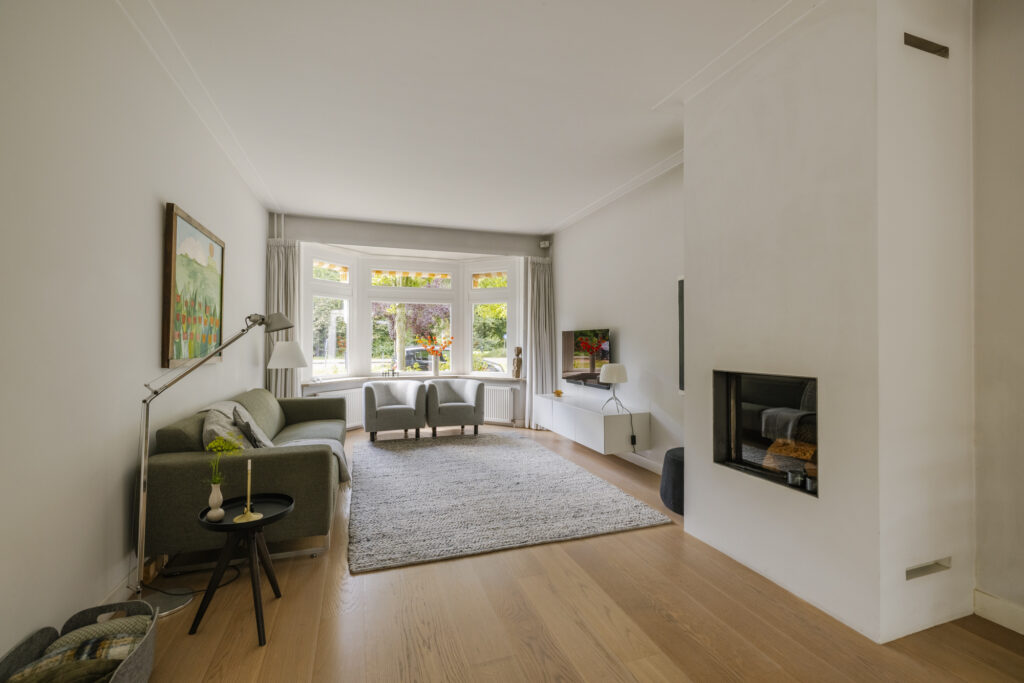 Cozy living room with large windows and fireplace.