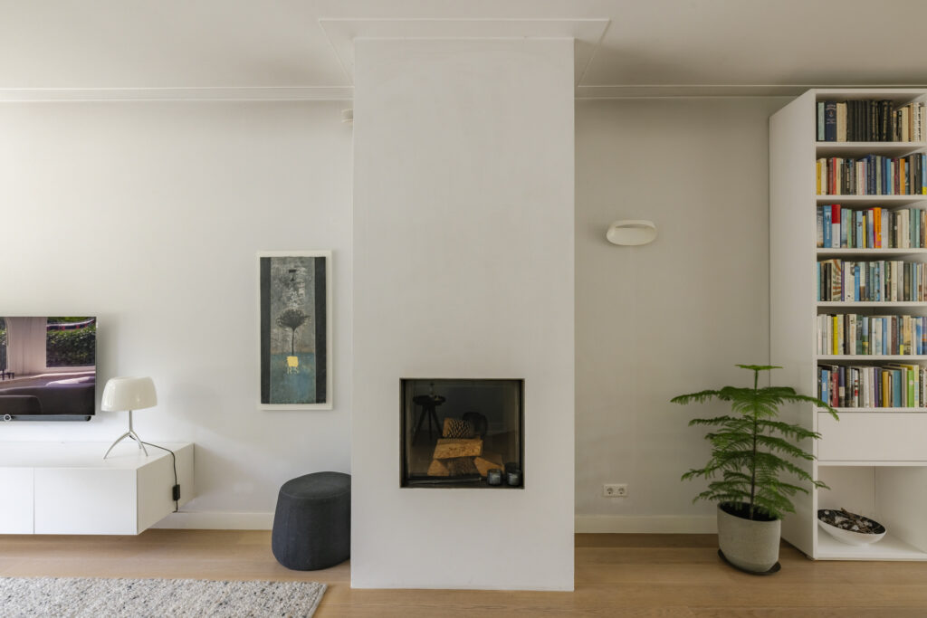 Modern living room with fireplace and bookshelf.