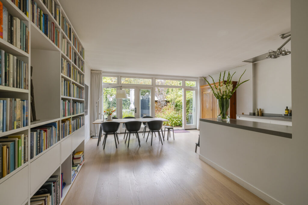 Modern dining room with bookshelf and large windows