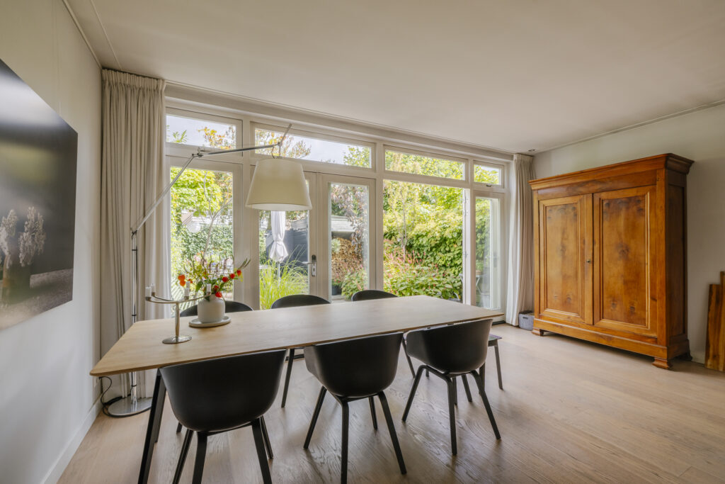 Bright dining room with wooden furniture and garden view.