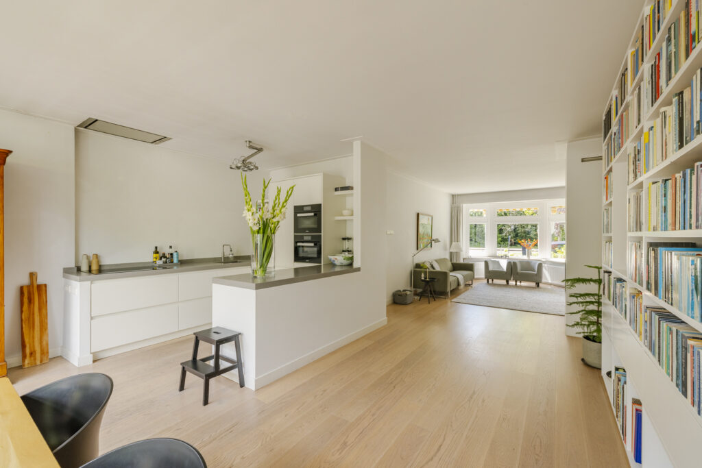 Modern open-plan kitchen and living room with bookshelves.