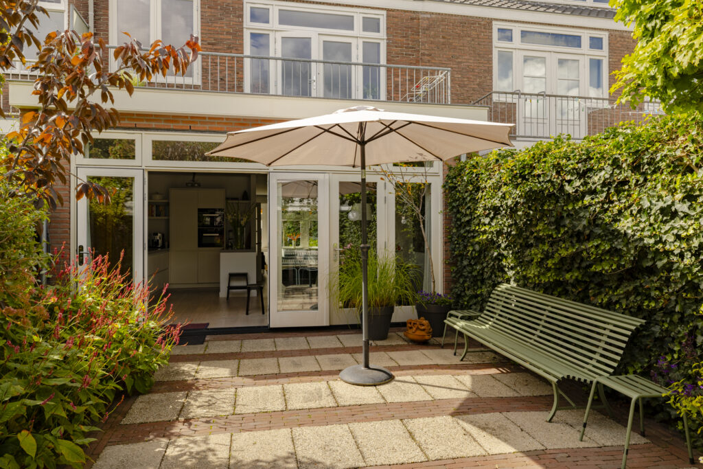 Backyard patio with bench and umbrella.
