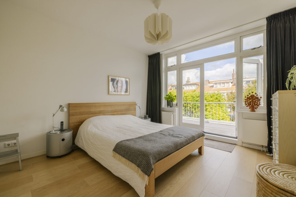 Bright bedroom with balcony and modern furniture.