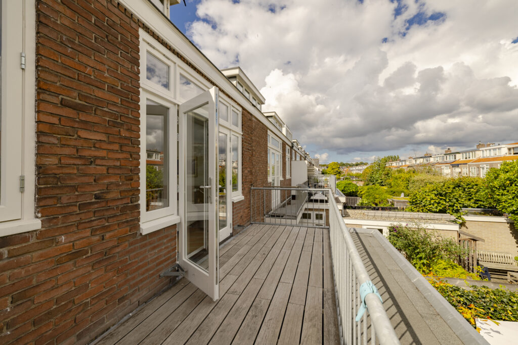 Sunny balcony with open door view.