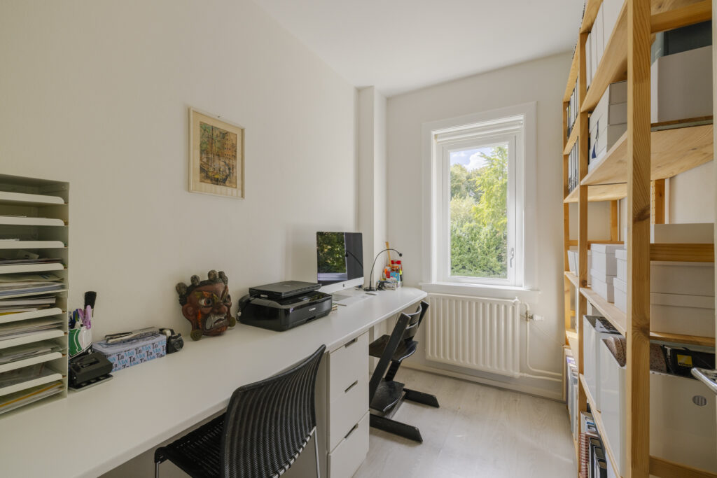Minimalist home office with desk and window view.