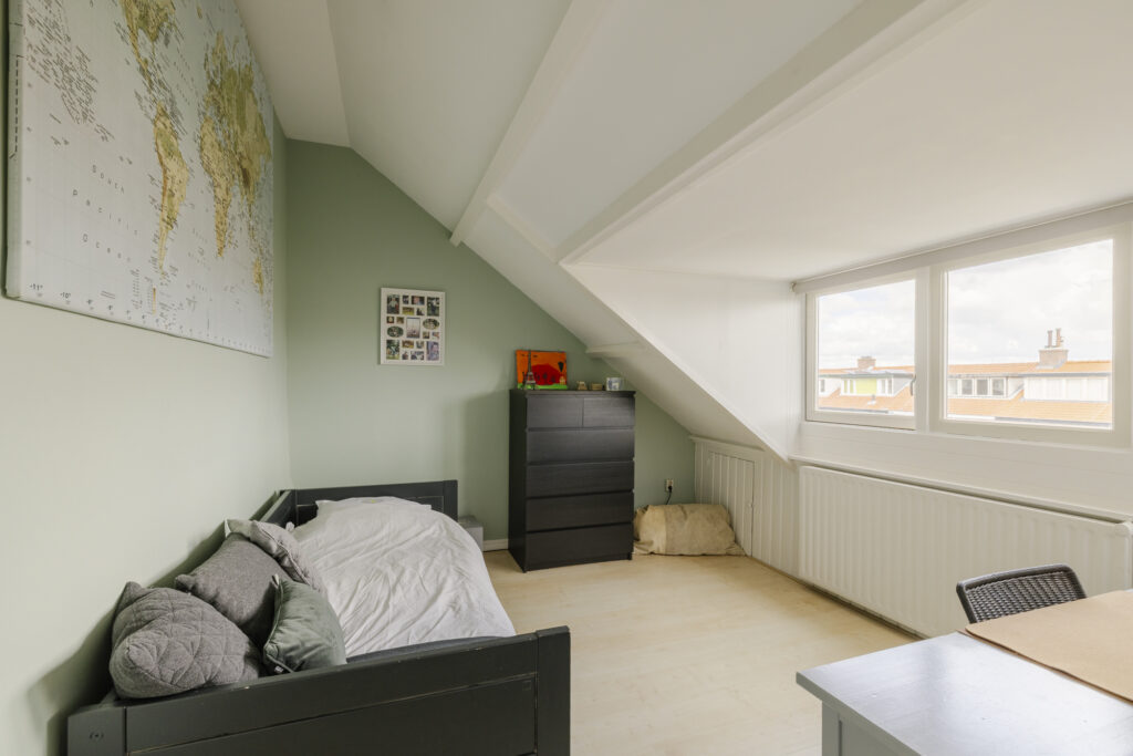 Small attic bedroom with world map decoration.