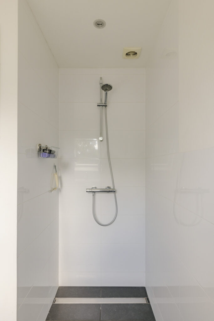 Modern tiled shower with metal fixtures