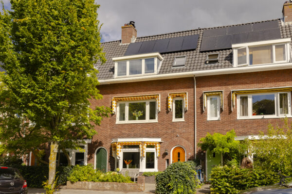 Brick house with solar panels and awnings.