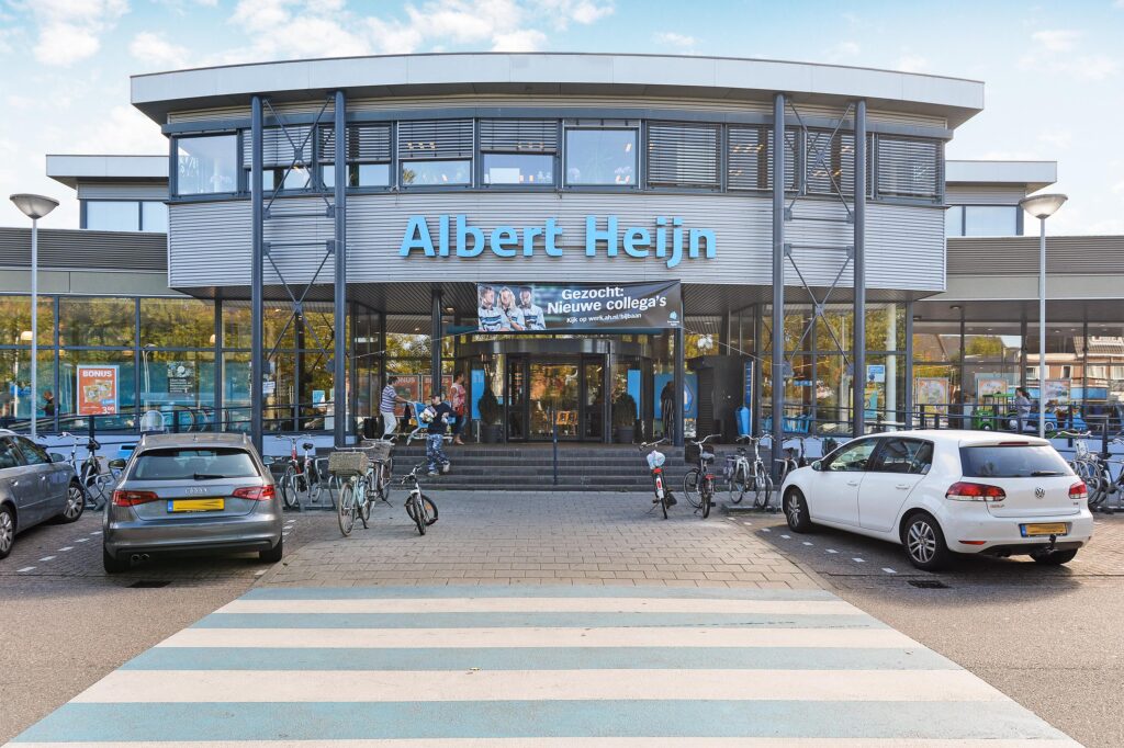 Albert Heijn supermarket entrance with parked cars