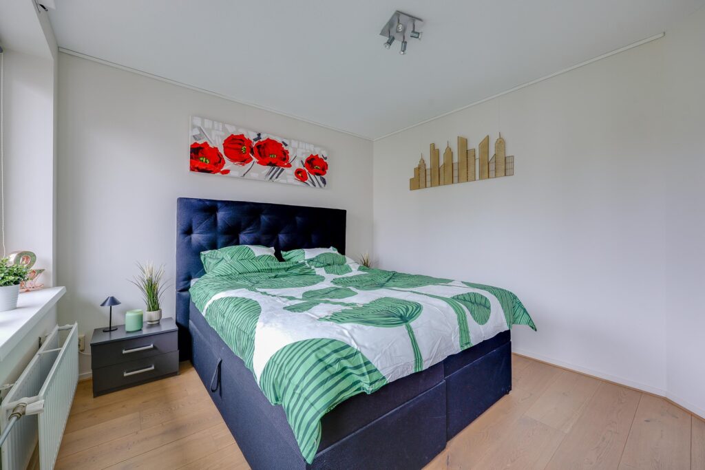 Modern bedroom with green bedding and artwork