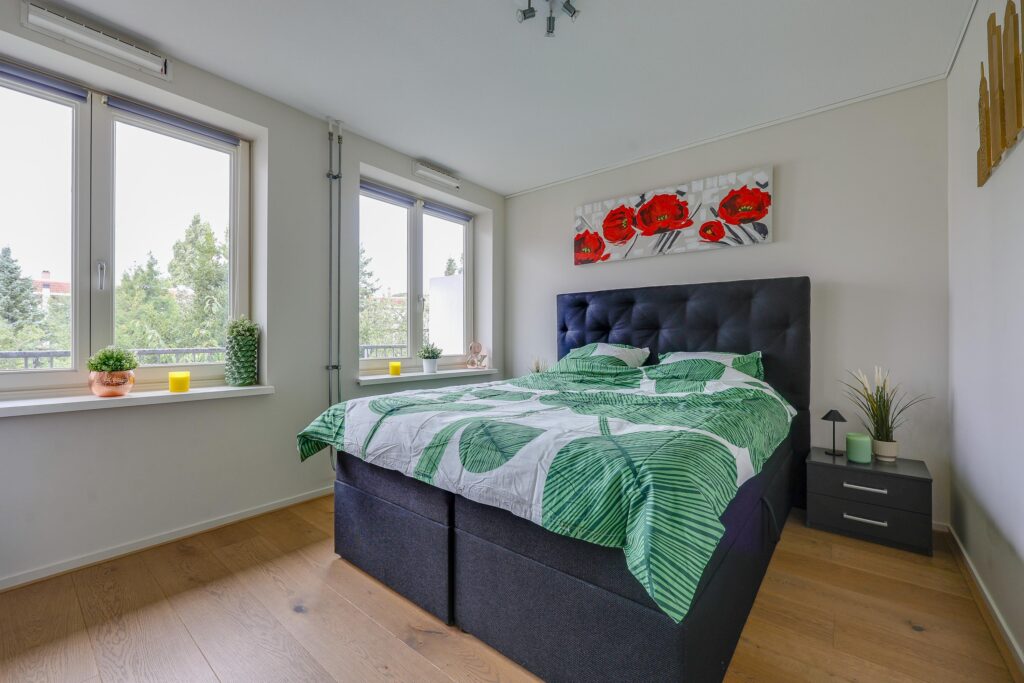 Modern bedroom with large windows and leafy bedding