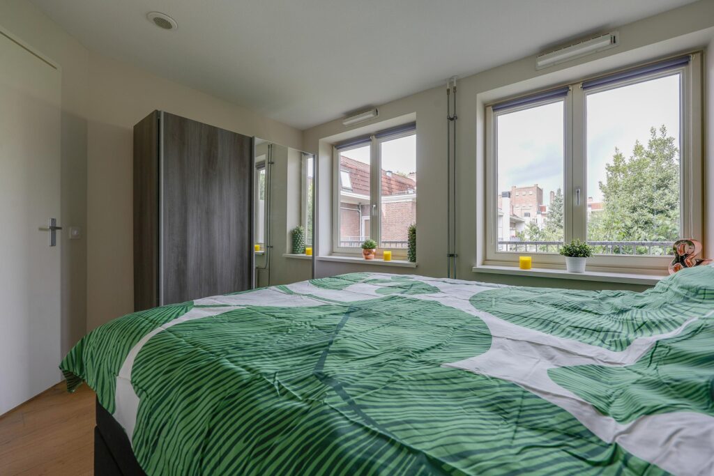 Bright bedroom with green leaf-patterned bedding