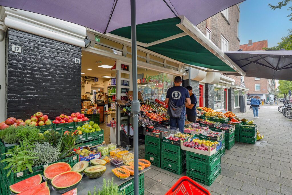 Outdoor produce market with fresh fruits and vegetables.
