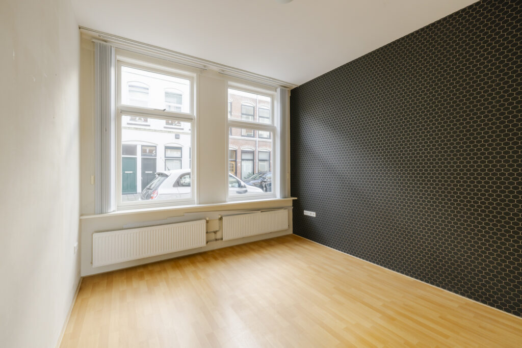 Empty room with wooden floor and large windows