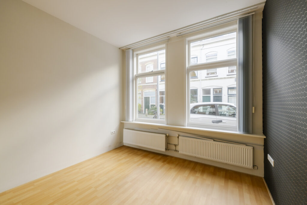Empty room with large windows and wooden floor