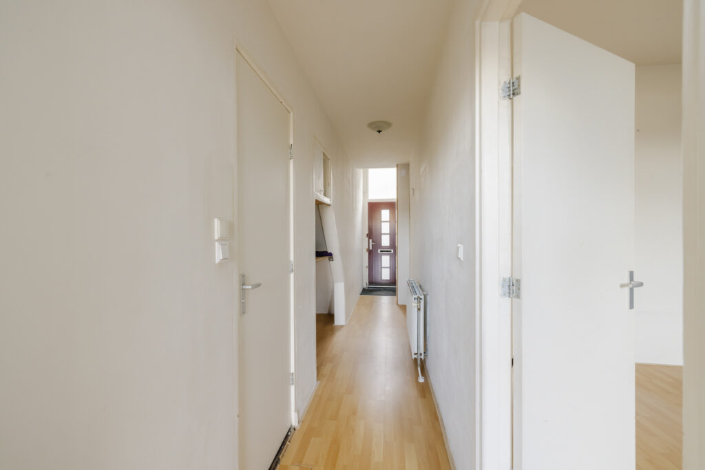 Bright hallway with wooden floor and open doors