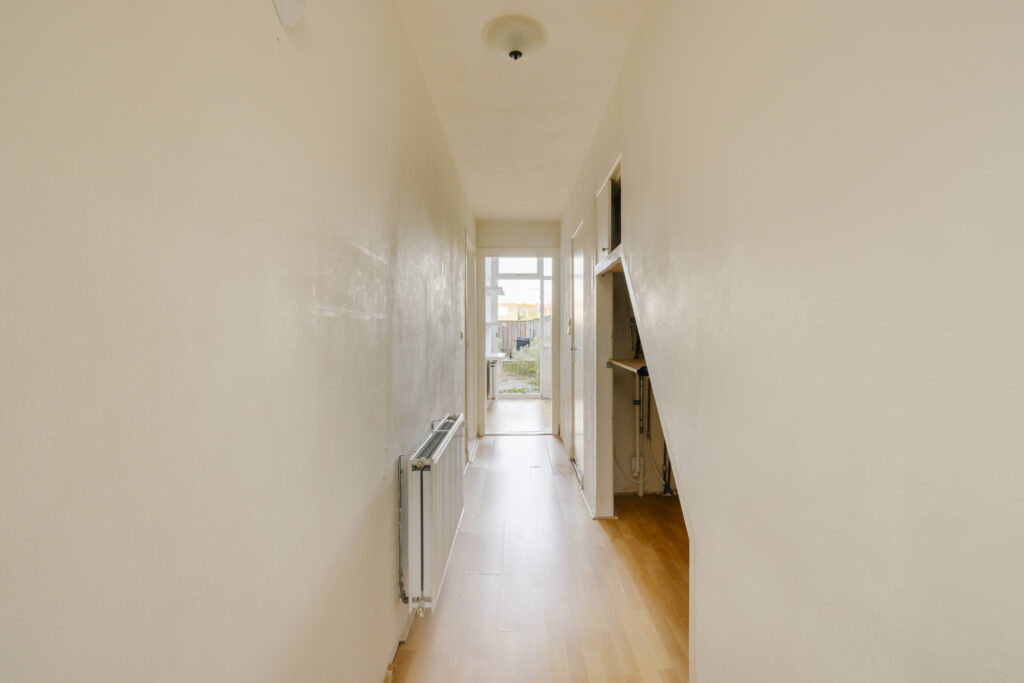 Narrow hallway leading to a garden view