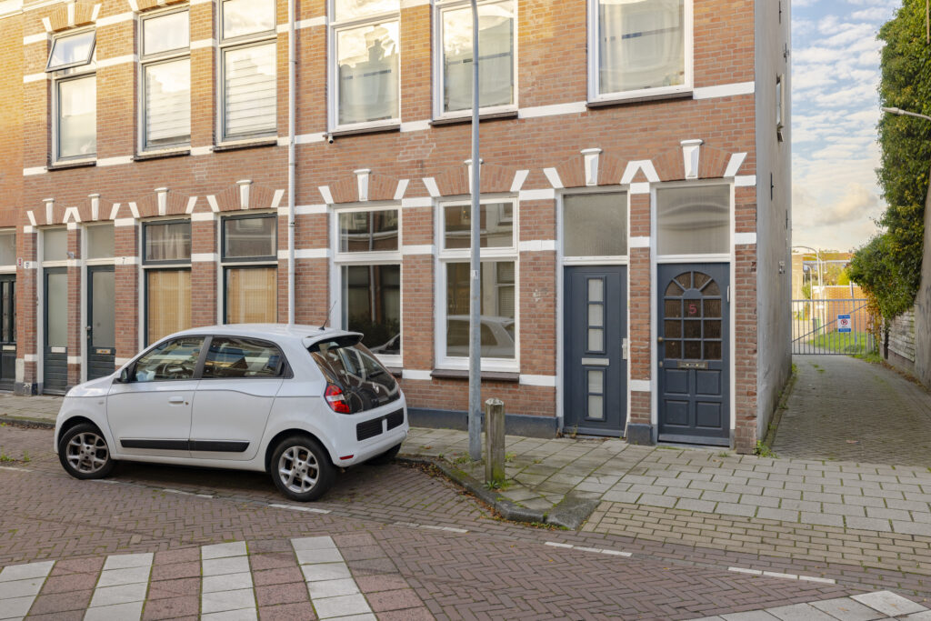 White car parked near brick building on street
