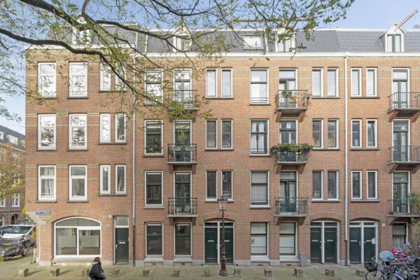 Brick apartment building with balconies and windows.