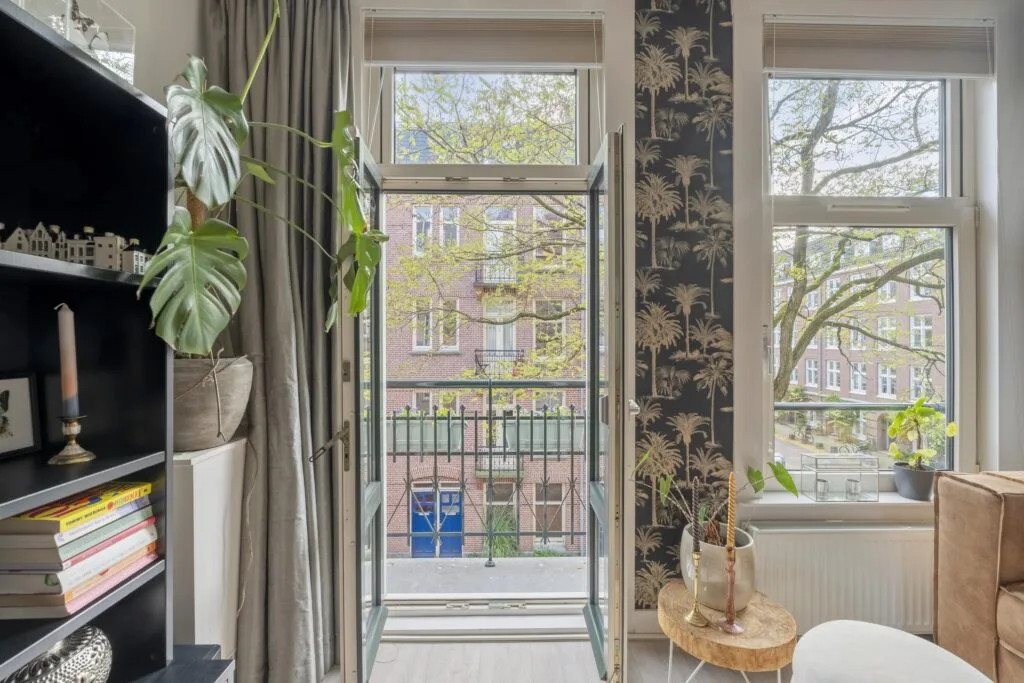 Sunny room with balcony and large windows view.