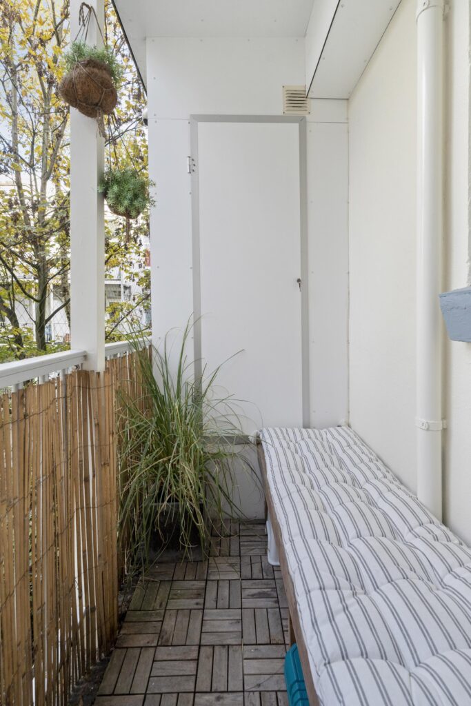 Small balcony with plants and cushioned bench
