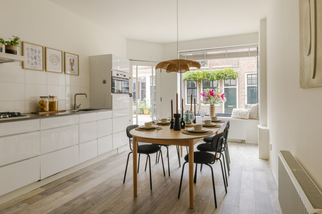 Modern kitchen with dining table and window view.
