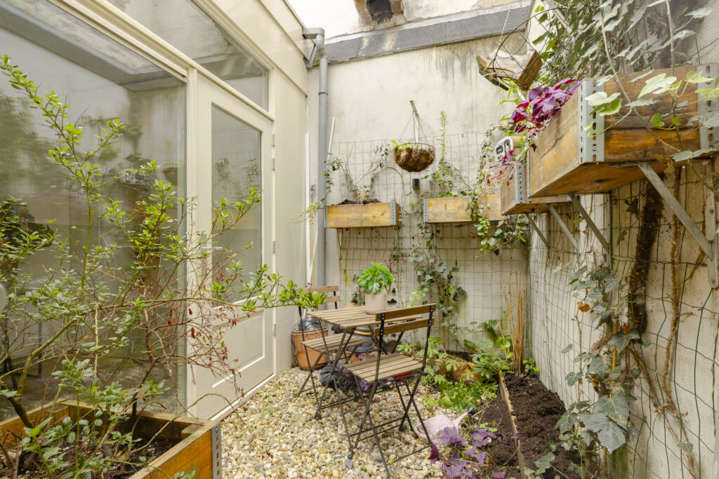 Small urban garden with patio furniture and plants.
