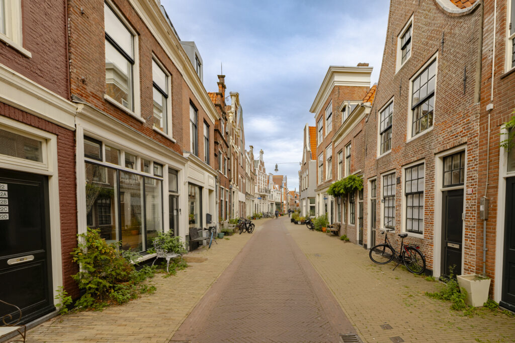 Narrow European street with brick buildings and bikes.