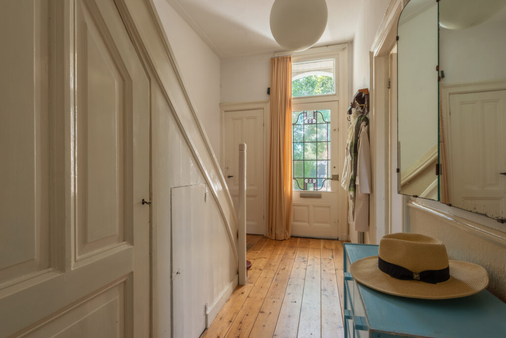 Bright hallway with wood floor and stained glass window.