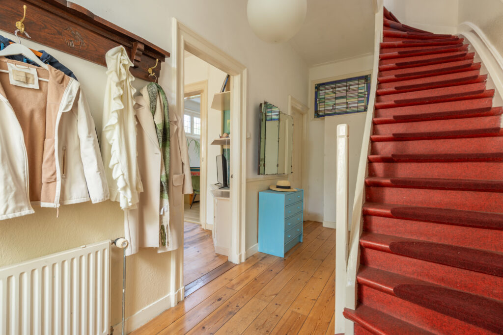 Cozy hallway with red carpeted stairs
