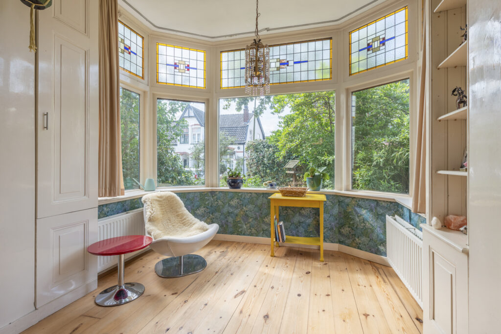 Bright bay window with stained glass and cozy chair