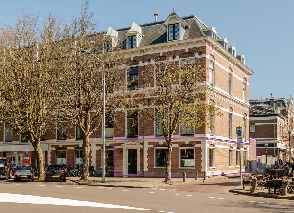 Historic brick building with trees on street corner.