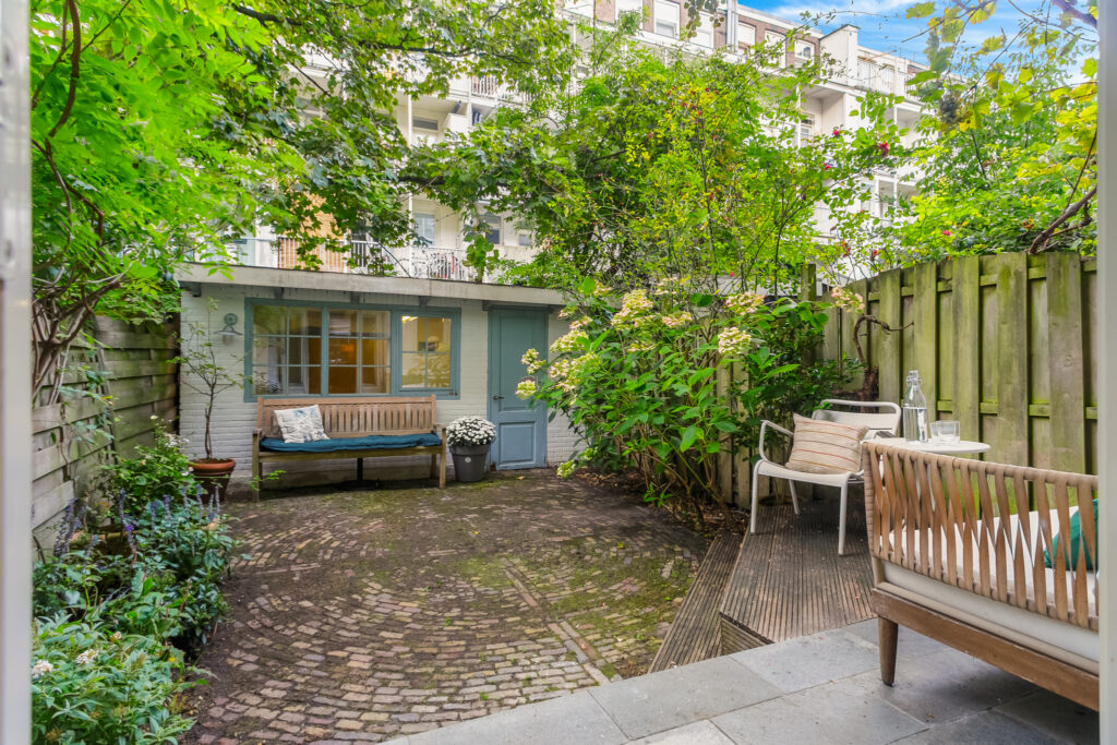Cozy garden patio with benches and greenery.