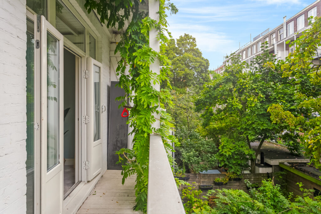 Open balcony with greenery and view of nature.