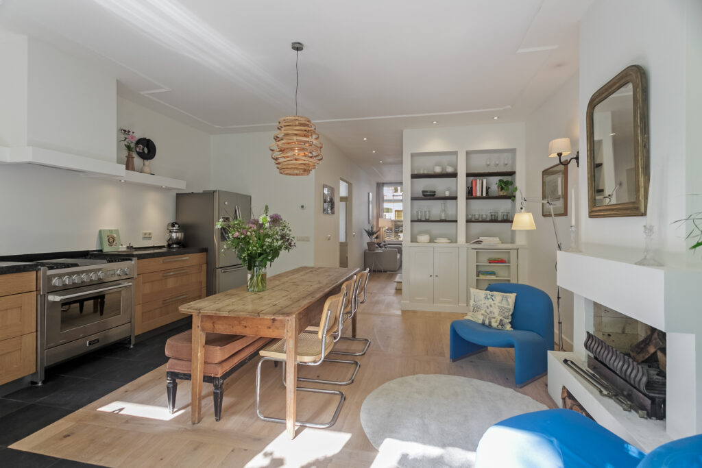 Modern kitchen and dining area with wooden table.