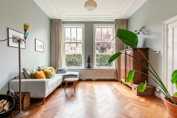 Spacious living room with large windows and hardwood floor.