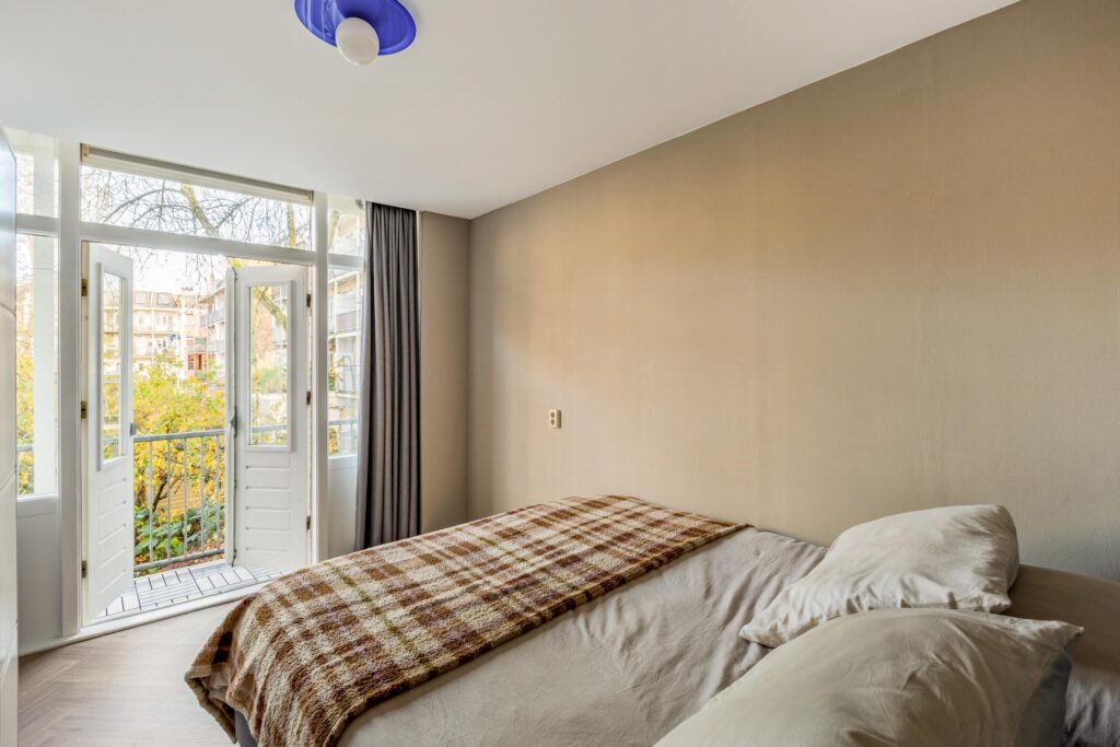 Bedroom with open doors to balcony view.