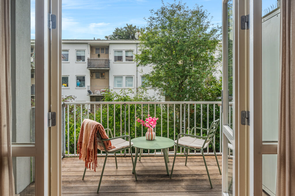 Cozy balcony with chairs and table view.