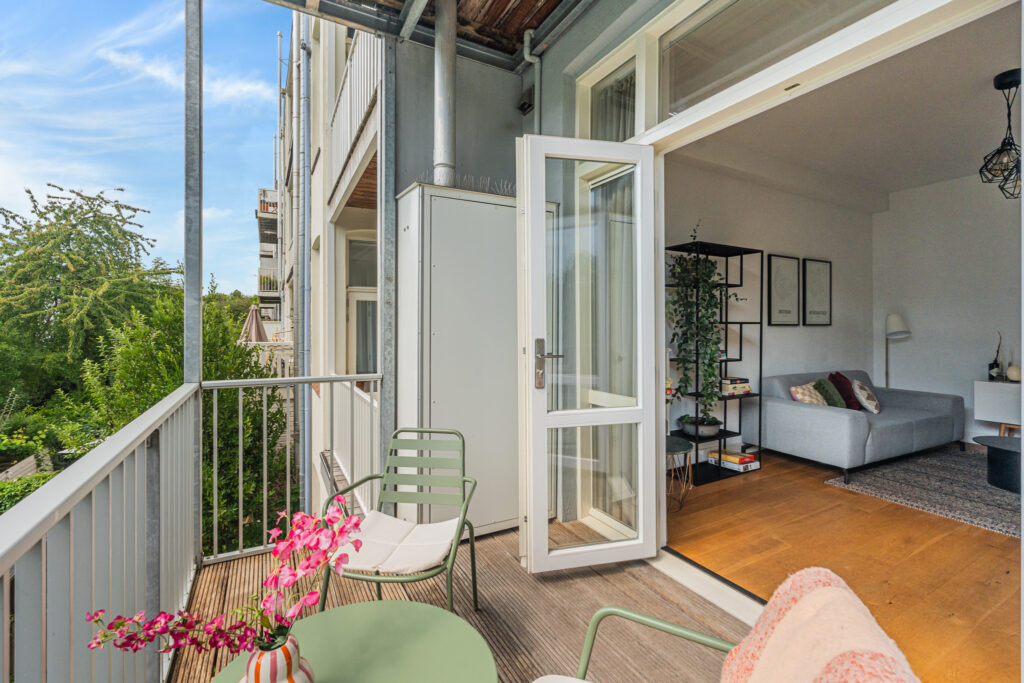 Cozy balcony and living room view with open door.