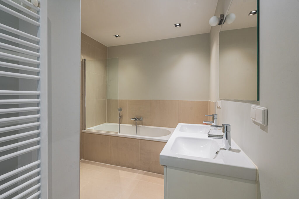 Modern bathroom with tub and dual sink.