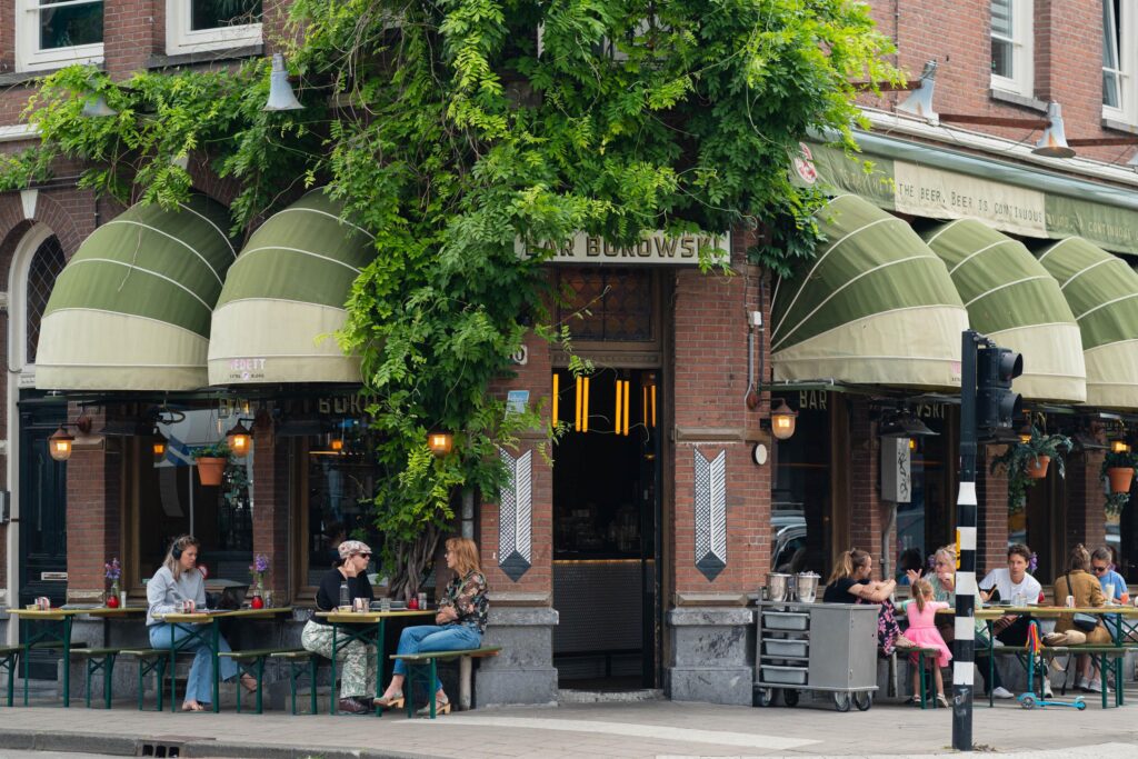Outdoor seating at a cafe with green awnings.