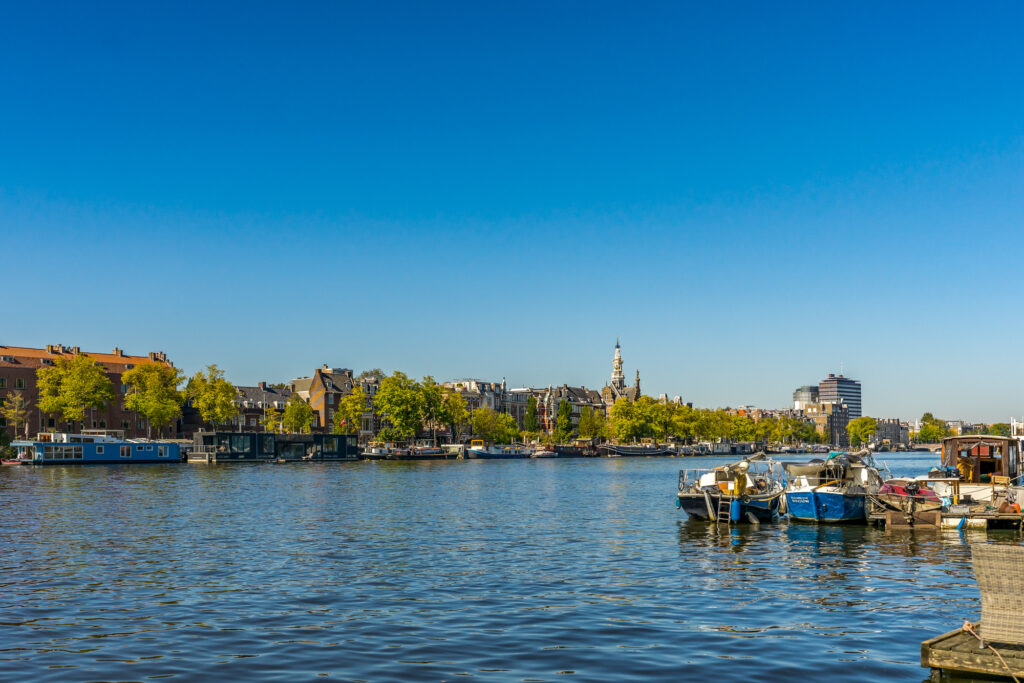 Amsterdam canal with boats and cityscape.