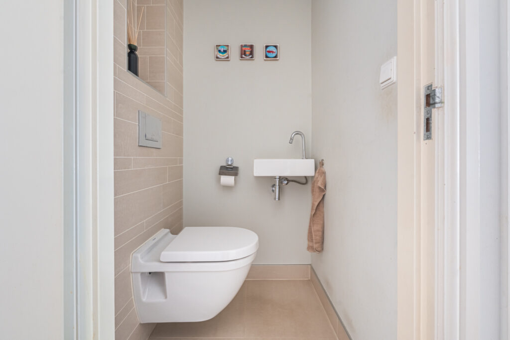 Compact modern bathroom with wall-mounted toilet and sink.