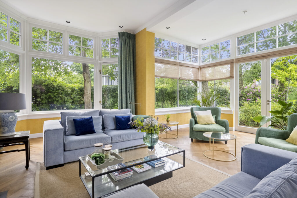Bright living room with large windows and green view.