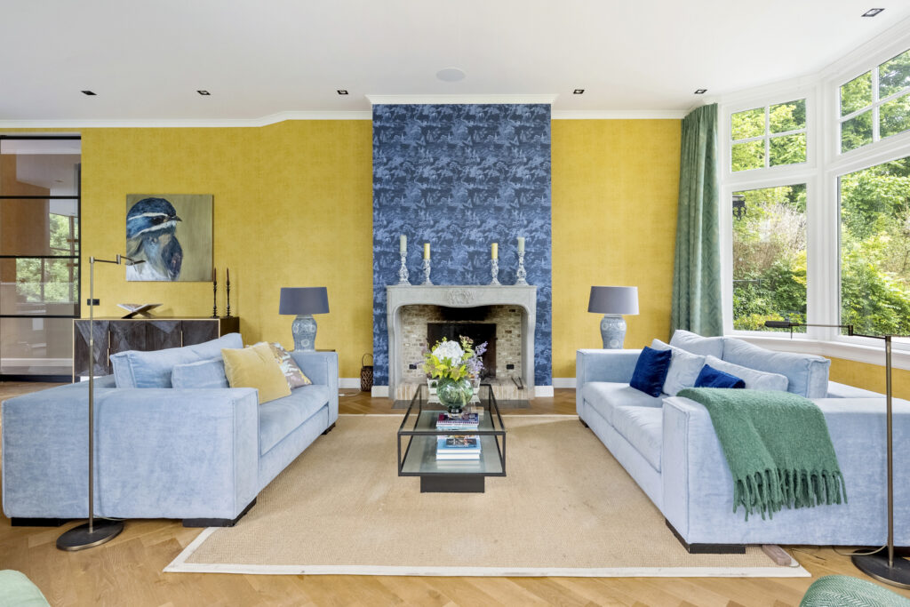 Modern living room with blue sofas and fireplace.