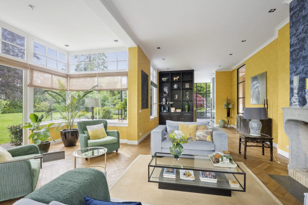 Bright living room with yellow walls and large windows.