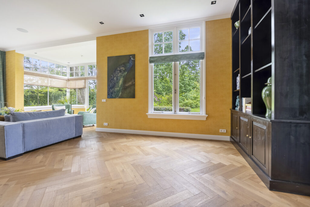 Spacious living room with large windows and yellow walls.