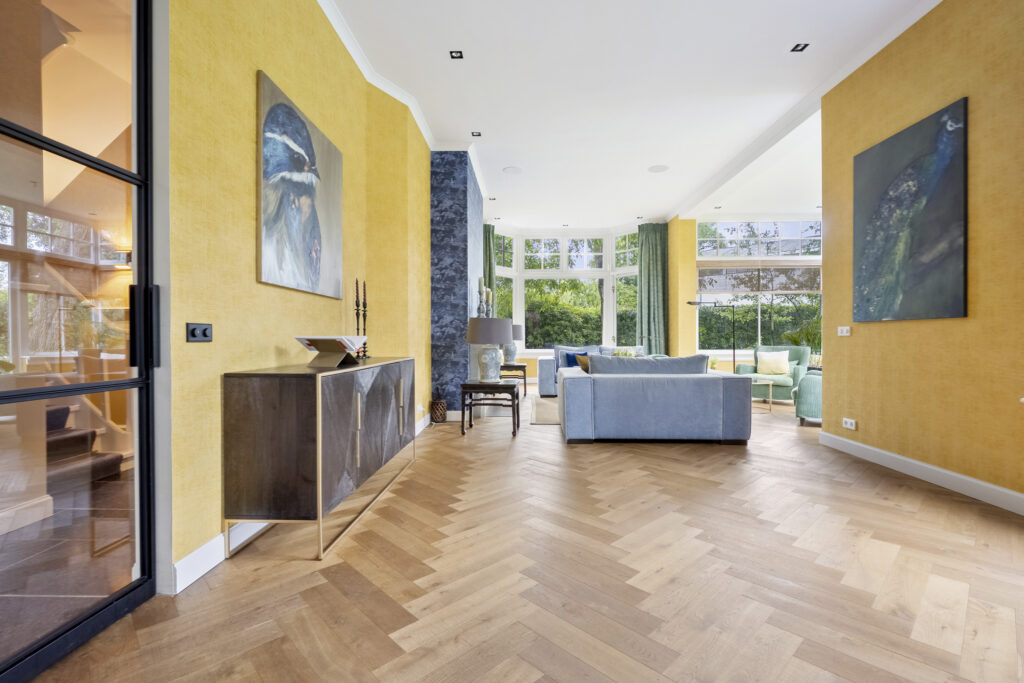 Spacious living room with yellow walls and large windows.