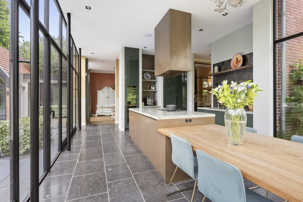 Modern kitchen with large windows and dining area.