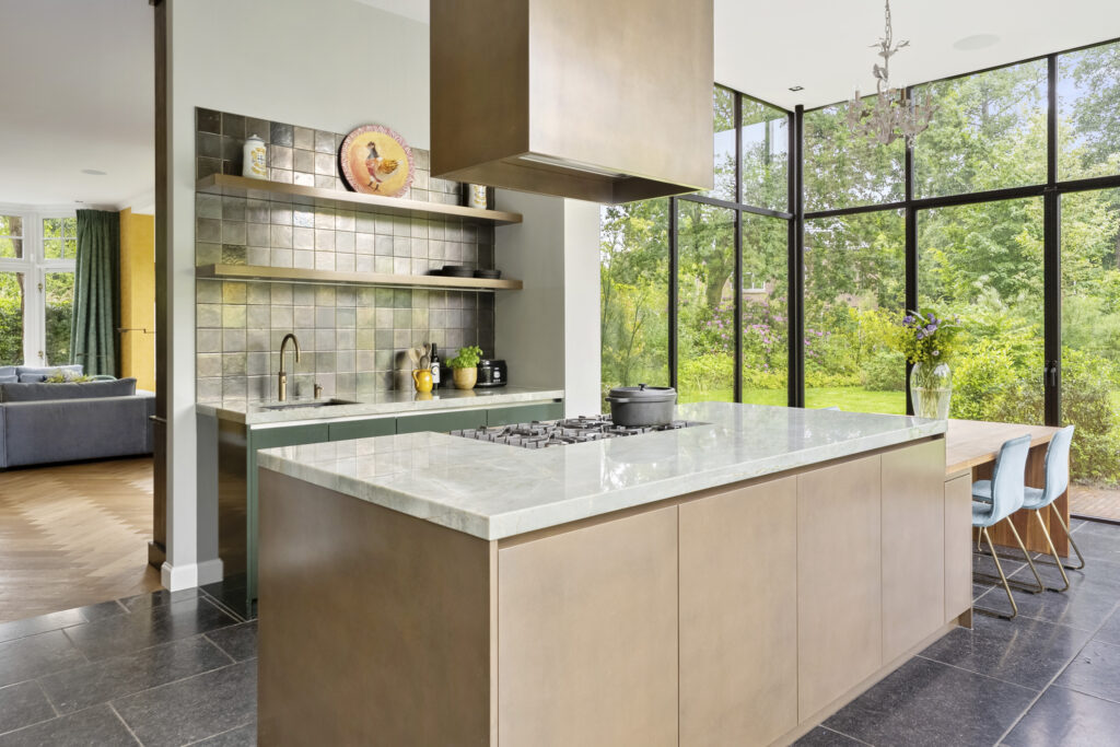 Modern kitchen with garden view through large windows.